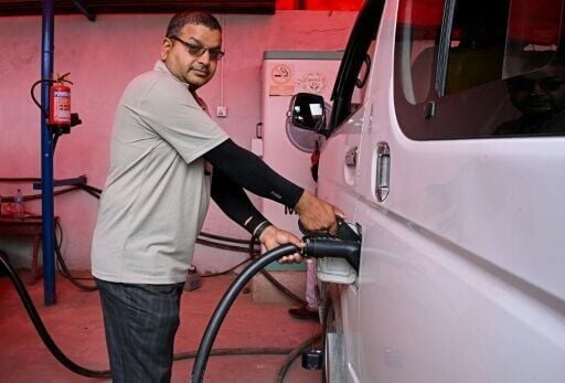 Electric microbus driver Purushottam Adhikari charges his Chinese-made e-van at a charging station in Kathmandu