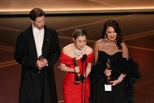 Co-director Chris Appelhans co-director Maggie Kang and producer Michelle Wong accept the Oscar for best animated feature for 'KPop Demon Hunters'