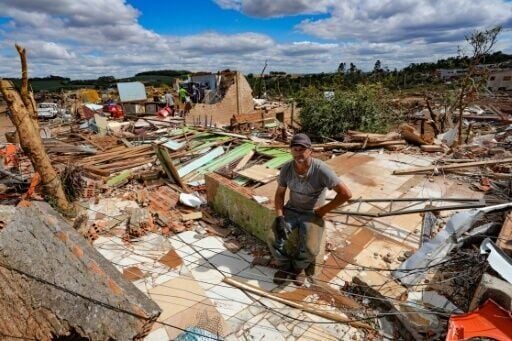 Nereu Sabadini sits on the debris of his house that was destroyed by a tornado in Rio Bonito do Iguaçu, Brazil