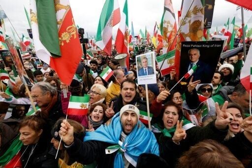 Iranian demonstrators hold flags and posters depicting Iran's former crown prince and now key opposition figure Reza Pahlavi in Munich