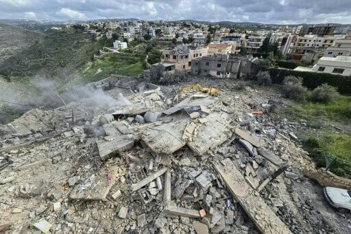 First responders at the rubble of a building targeted by an Israeli airstrike in the southern Lebanese village of Hanouiyeh