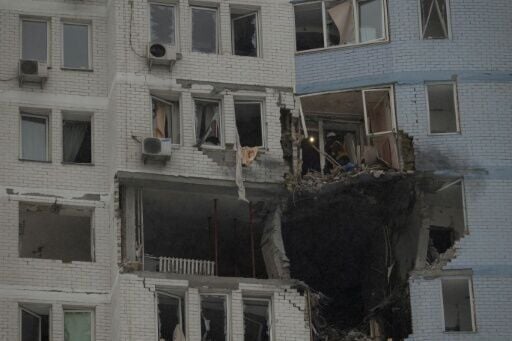 Firefighters clear debris in a damaged residential building following a Russian bombardment that killed at least four people