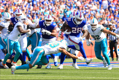 Buffalo Bills RB James Cook attempts to paint team logo with other