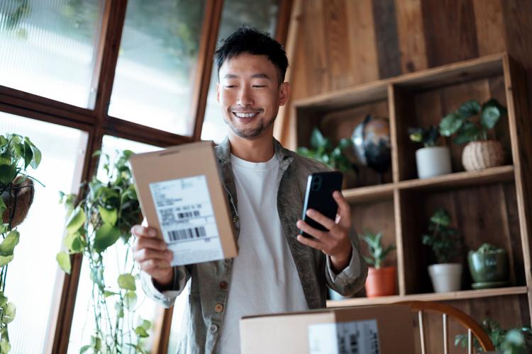 Smiling young Asian man received delivered packages