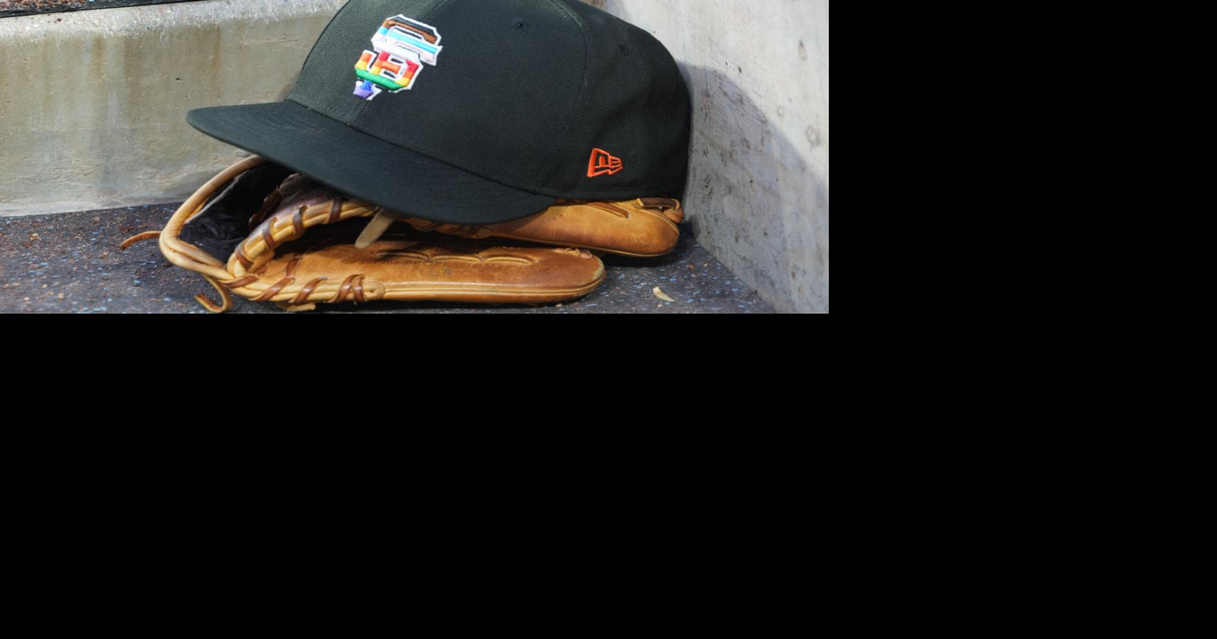A rainbow colored San Francisco Giants logo cap and a glove in the dugout during LGBTQ+ Pride Night at Dodger Stadium at Dodger Stadium on Jun 16, 2023.