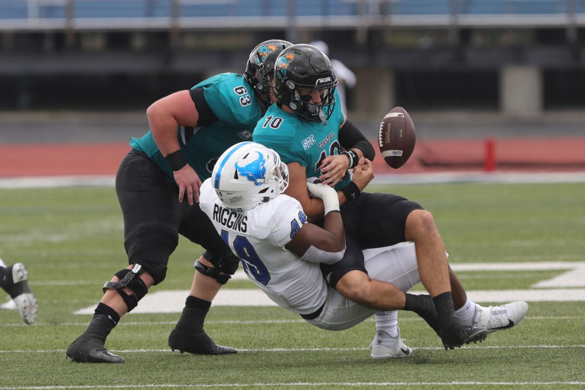 UB Bull's DE Taylor Riggins (49) tackles Coastal Carolina's quarterback Grayson McCall (10) causing him to fumble but Carolina recovered the ball.