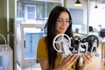 Designer holding a 3D printed model at a creative studio