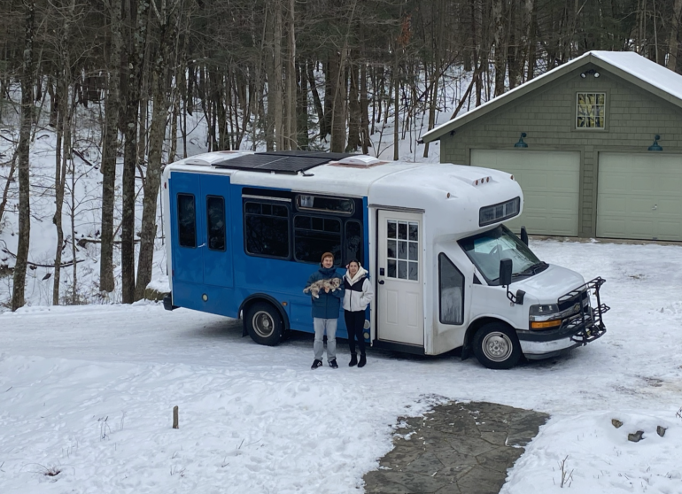 Dan Howson and Bo Bean stand outside their bus with their dog, Taro. The couple converted the bus into a living space in 2020.