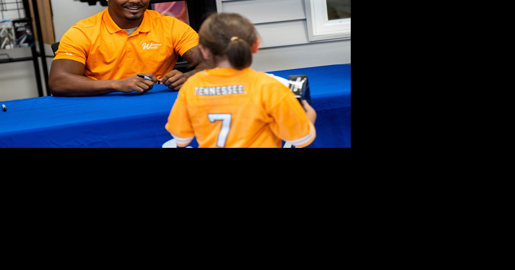 Tennessee linebacker Arion Carter smiles as he tells a young Vols fan that he likes her jersey during a meet and greet at Window
