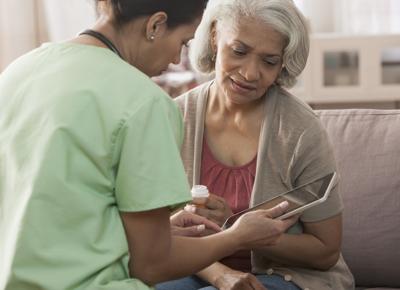 Nurse and older patient using tablet computer