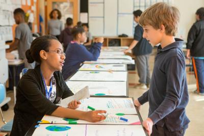 Girl and boy talk in middle school science class