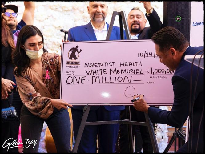 De La Hoya signing the check for his donation – Courtesy of Golden Boy Promotions main