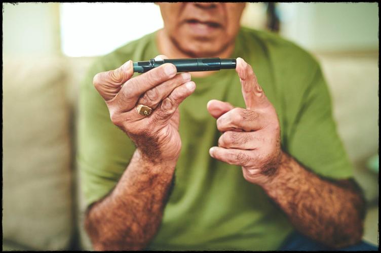 Shot of a senior man using a finger pricking device to check his blood sugar levels