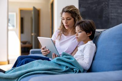 Mother and her sick son talking to the doctor on a video call from home