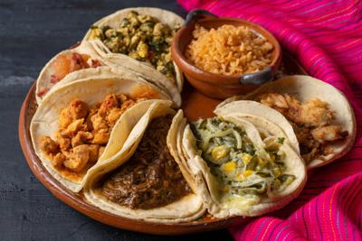 Mexican stew tacos also called "stews" with rice on dark background
