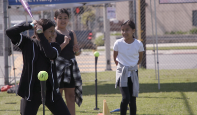 Young girl gearing up to hit a baseball