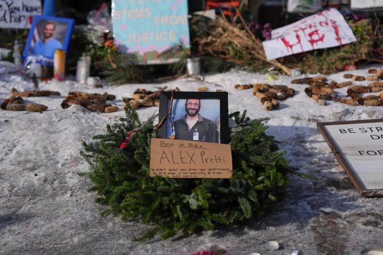 A sidewalk memorial set up with photos of Alex Pretti