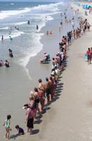 Hands Across draws about 60 people  to support clean energy, clean oceans and beaches