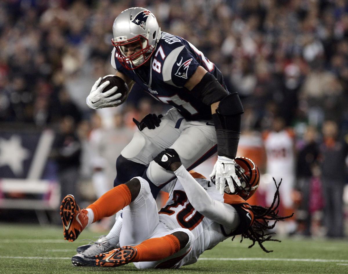 New England Patriots tight end Rob Gronkowski (87) runs over Cincinnati Bengals safety Reggie Nelson (20) after catching a short pass from quarterback Tom Brady.