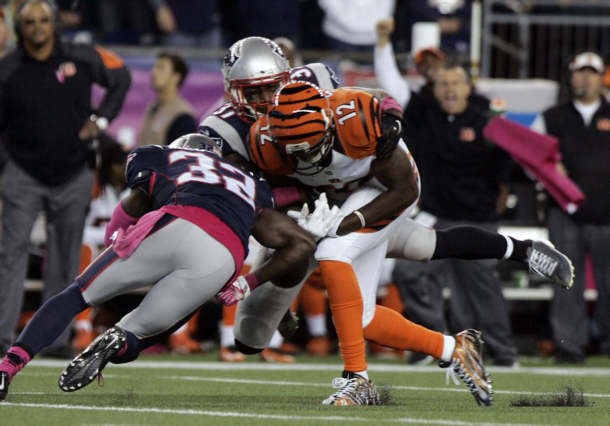 New England Patriots safety Devin McCourty (32) puts his shoulder into Cincinnati Bengals wide receiver Mohammed Sanu (12) to dislodge the ball.