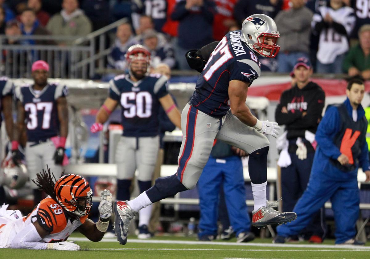 New England Patriots tight end Rob Gronkowski (87) manages to break away from Cincinnati Bengals linebacker Emmanuel Lamur (59) and turns upfield for a Patriots first down on Sunday evening.