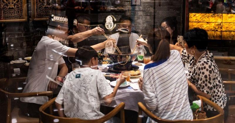 Photo: Central Oregon Daily Diners share a meal around a Chinese hot pot table at a traditional restaurant in Beijing