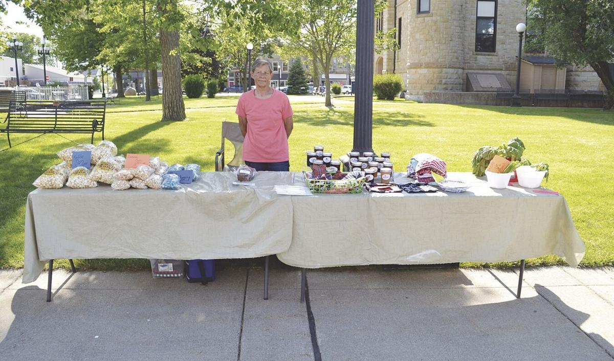 Kathy Dolan standing by tables of items.tif