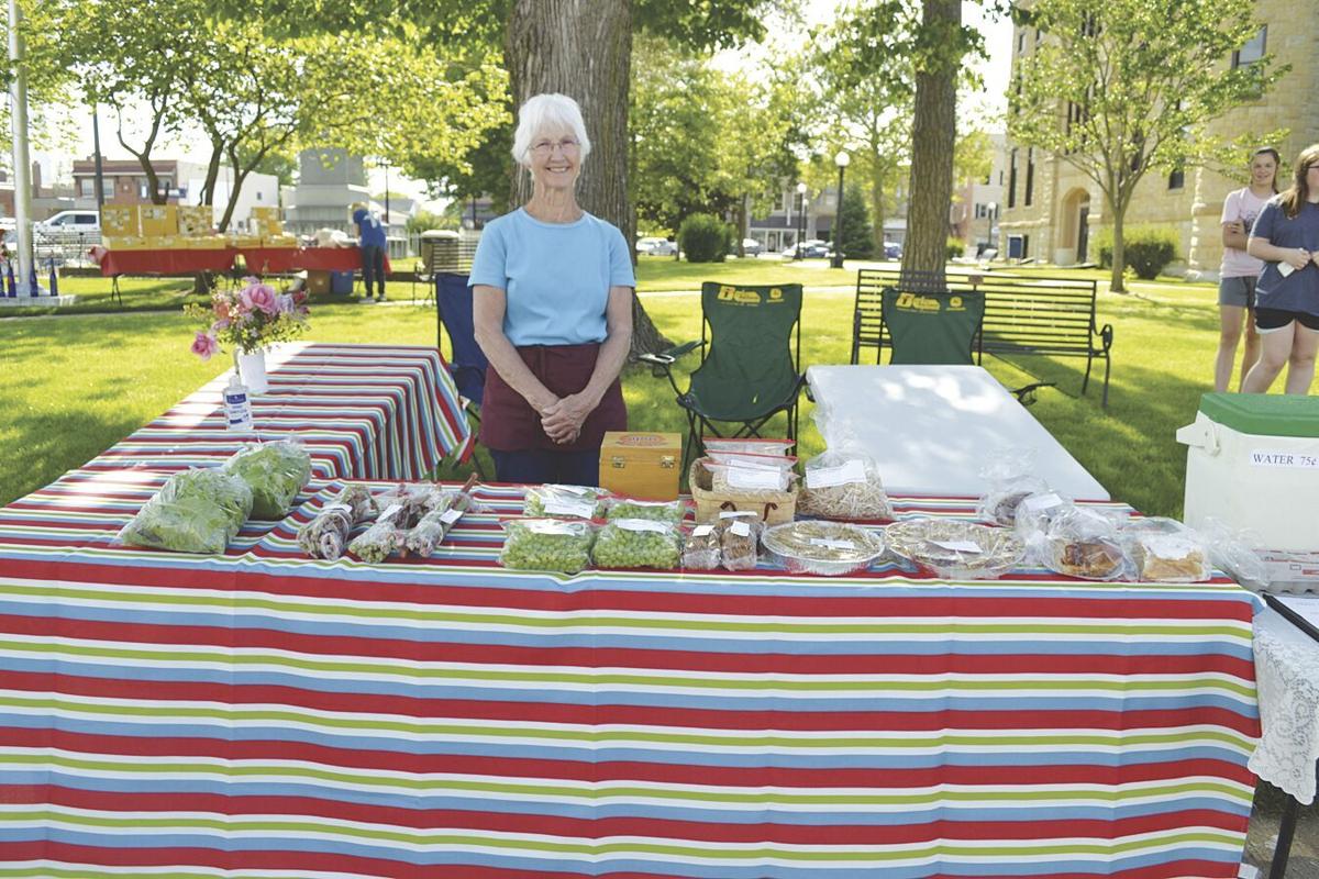 Louise Narber standing by table of items at Farmers Market.tif