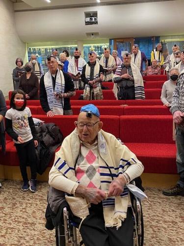 Dr. Malcolm Brahms sits at the front of the morning minyan