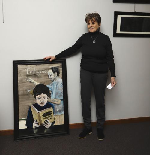 Billie Davids with painting of grandson at river arts center