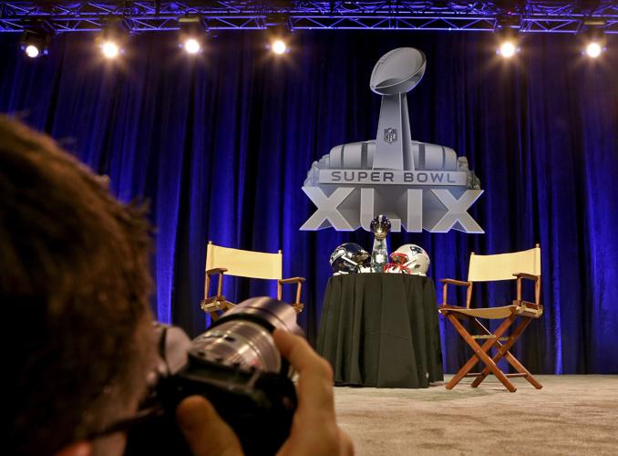 The Vince Lombardi Trophy sits with Seattle Seahawks and New England Patriots helmets before a joint press conference with the head coaches in Phoenix.