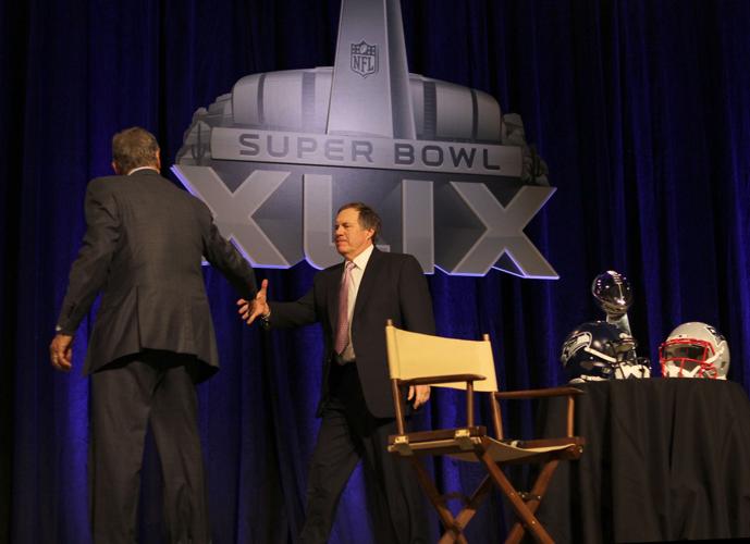 New England Patriots head coach Bill Belichick, right, extends a hand to Seattle Seahawks head coach Pete Carroll after their joint press conference in Phoenix.