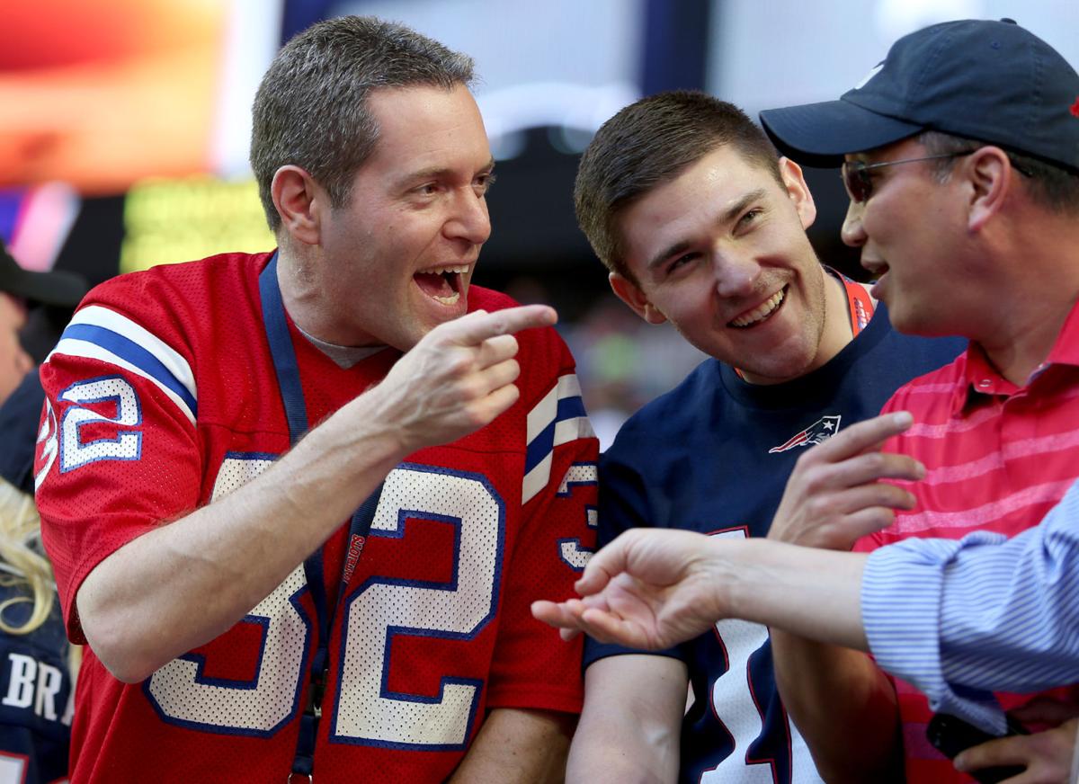 Barry Finegold talks to a fan as EJ Schneider, center, looks on before the start of Super Bowl XLIX.