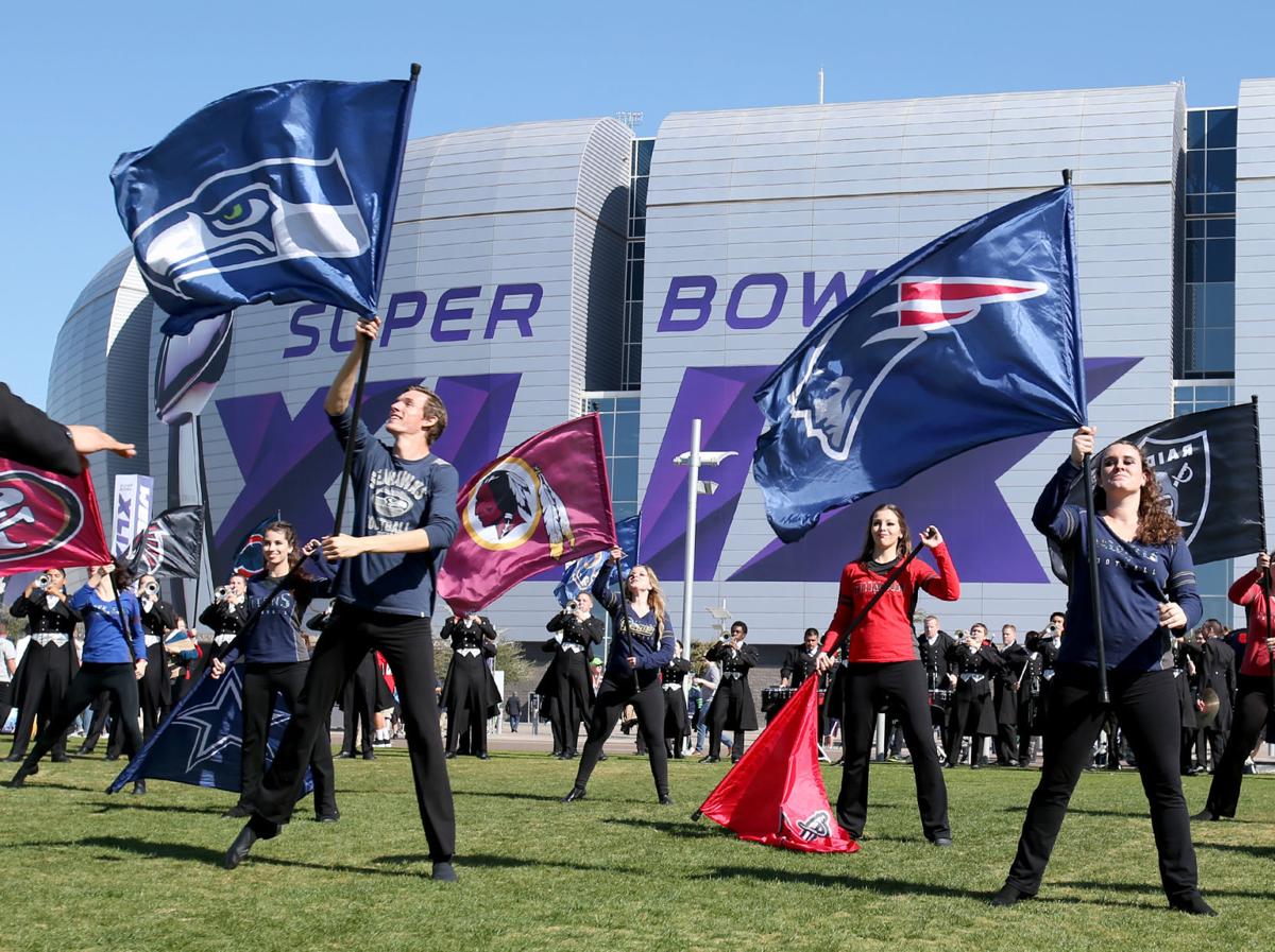 Cheerleaders twirl the Seattle Seahawks and New England Patriots flags outside the stadium before the start the game.
