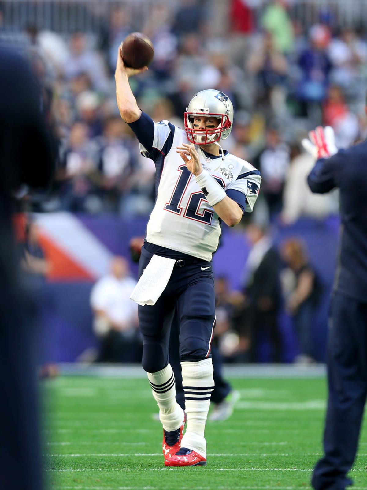 New England Patriots quarterback Tom Brady (12) takes warm up throws before the start of Super Bowl XLIX.
