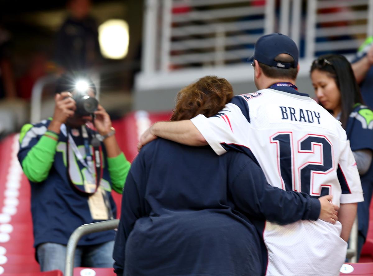 A Seattle Seahawks fan takes photos of New England Patriots' fans before the start of the game.