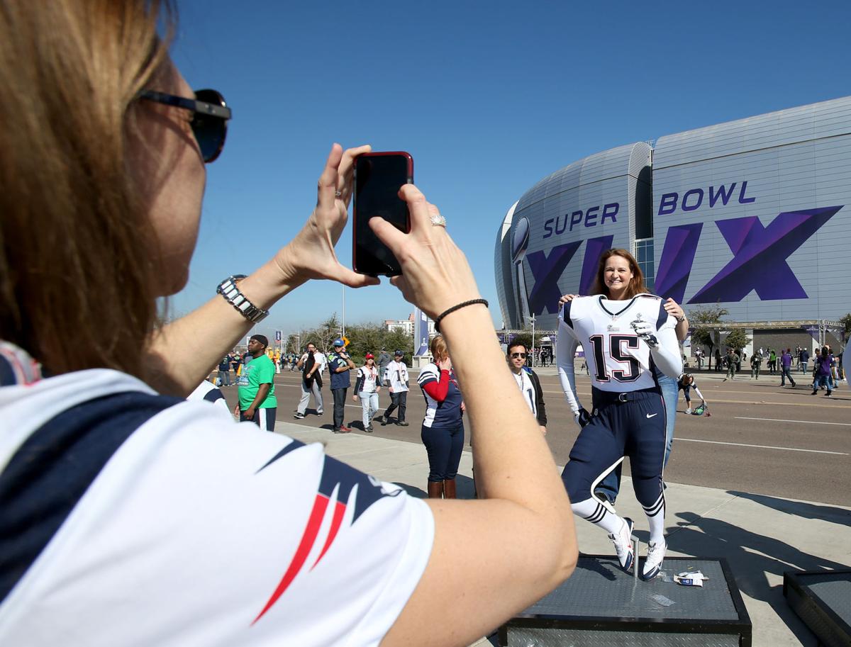 New England Patriots fans pose for photos outside the stadium.