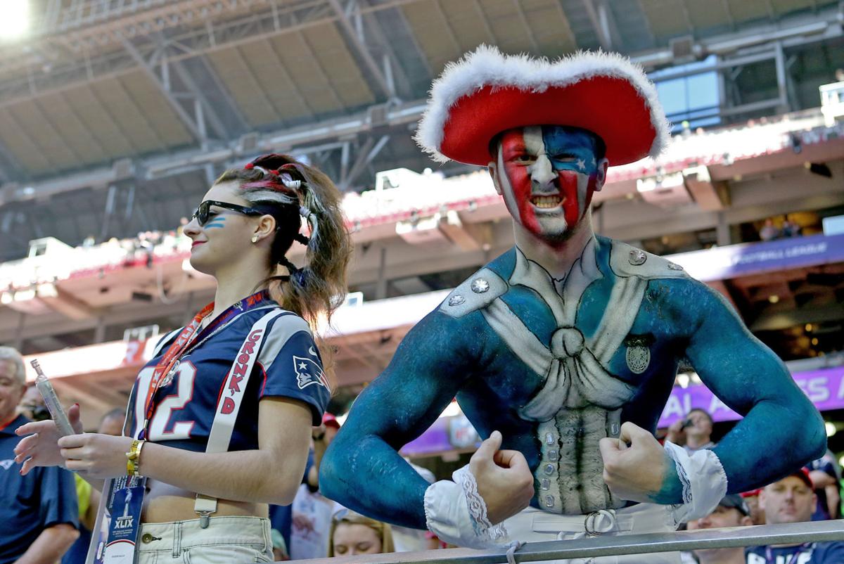 A New England Patriots fan poses as his friend looks away before the start of Super Bowl XLIX.