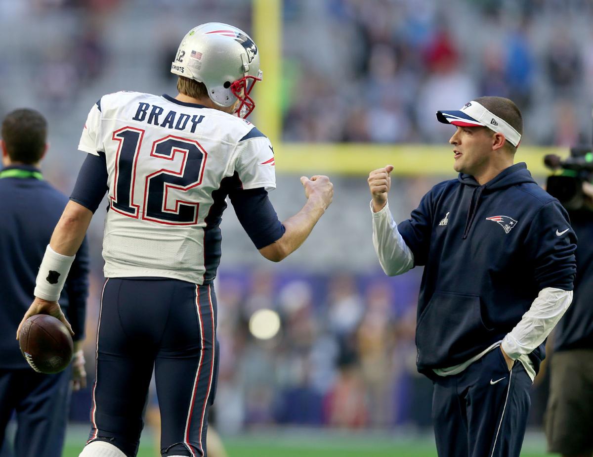 New England Patriots quarterback Tom Brady gets a fist bump from offensive coordinator Josh McDaniels.