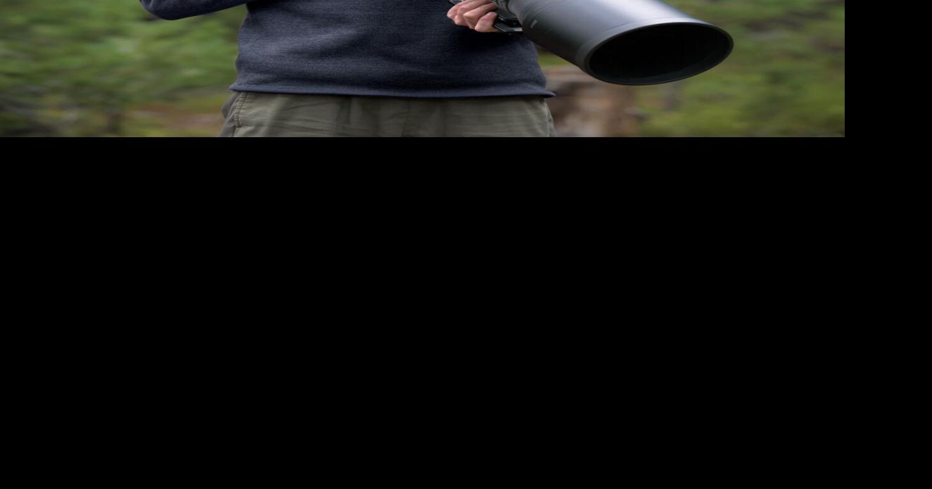 Wildlife photographer looks into her book at library talk