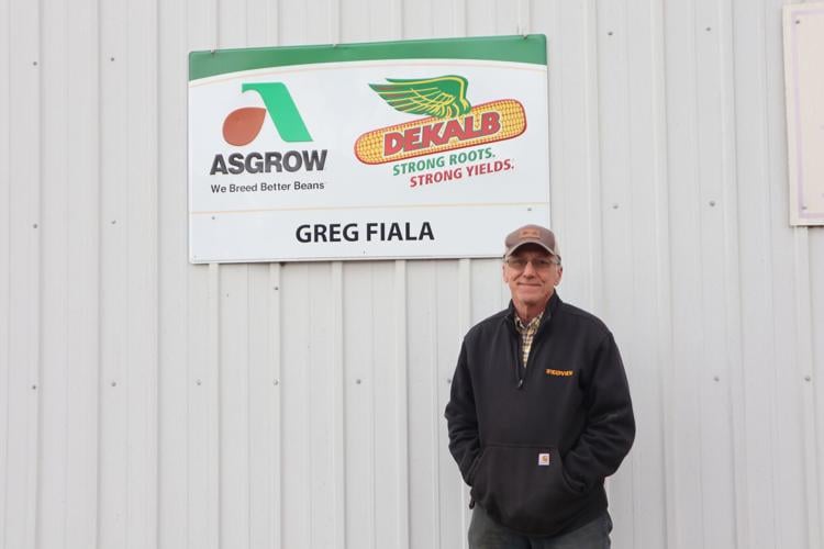 Greg Fiala next to a sign