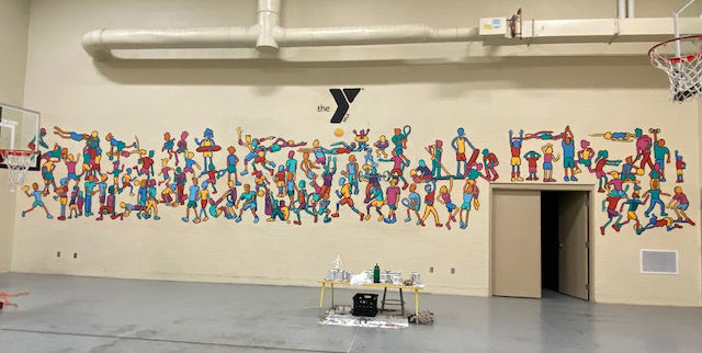 Scotus teacher painting mural at YMCA