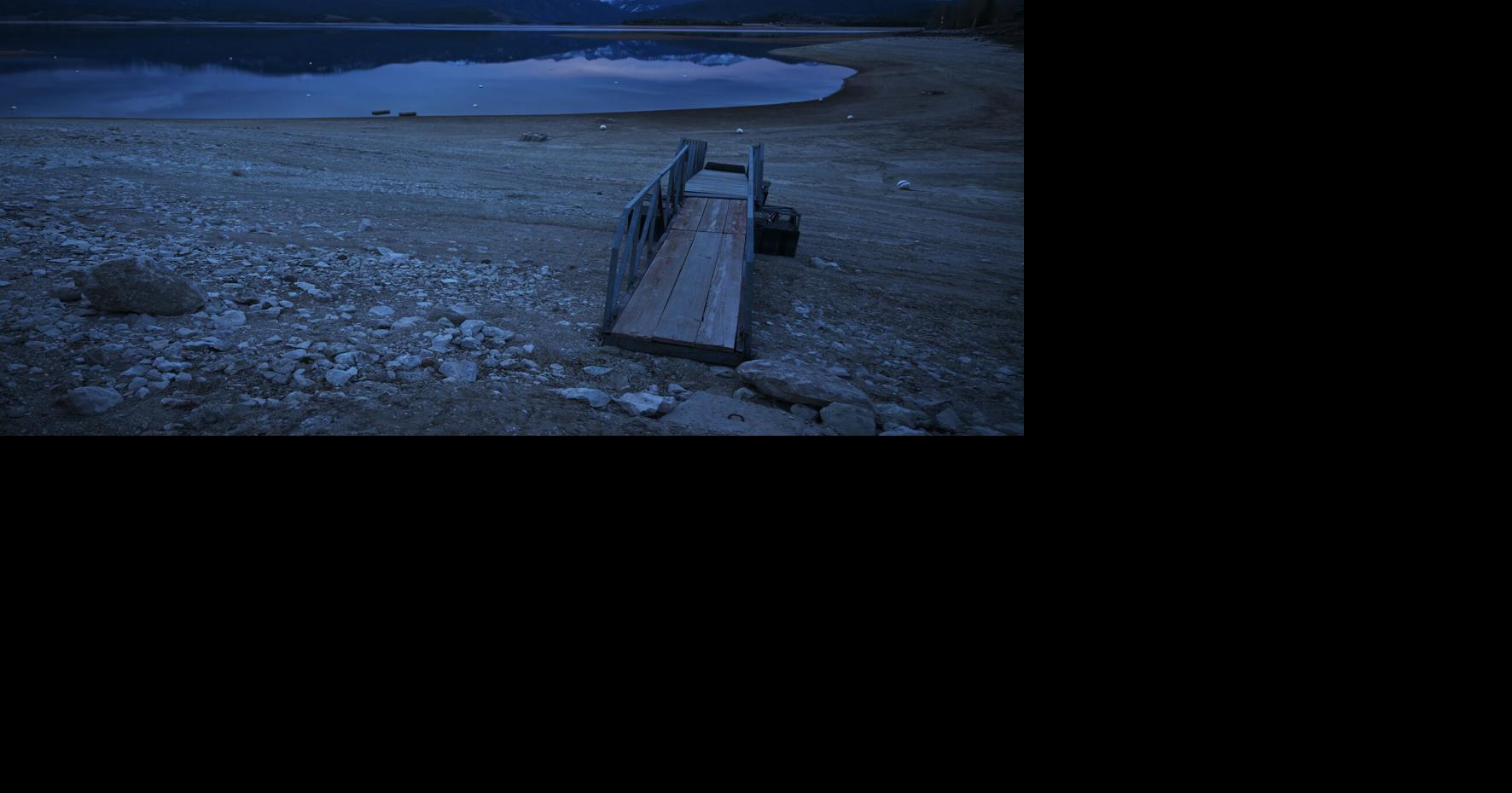 Dry lakebed is exposed near Indian Peaks Marina during low water levels at Lake Granby on April 7, 2026, near Granby, Colo. Lake Granby, a reservoir in the upper Colorado River system, is fed by the Colorado River.