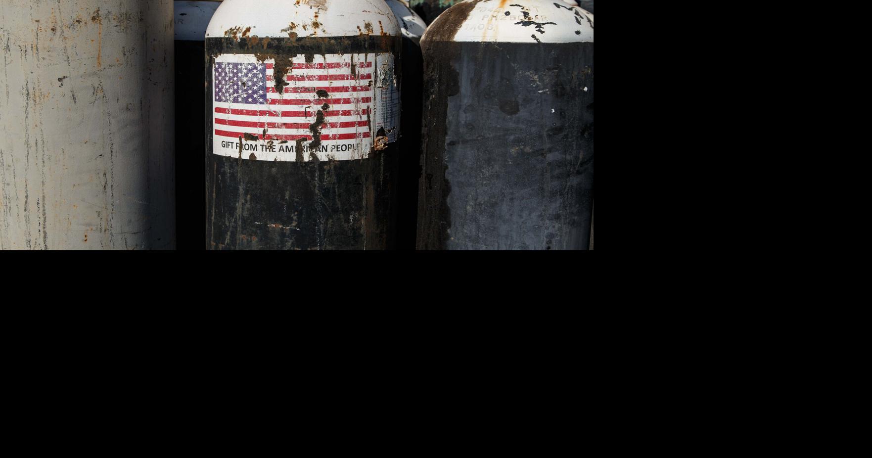An oxygen canister shows a worn sticker of the American flag with the words 