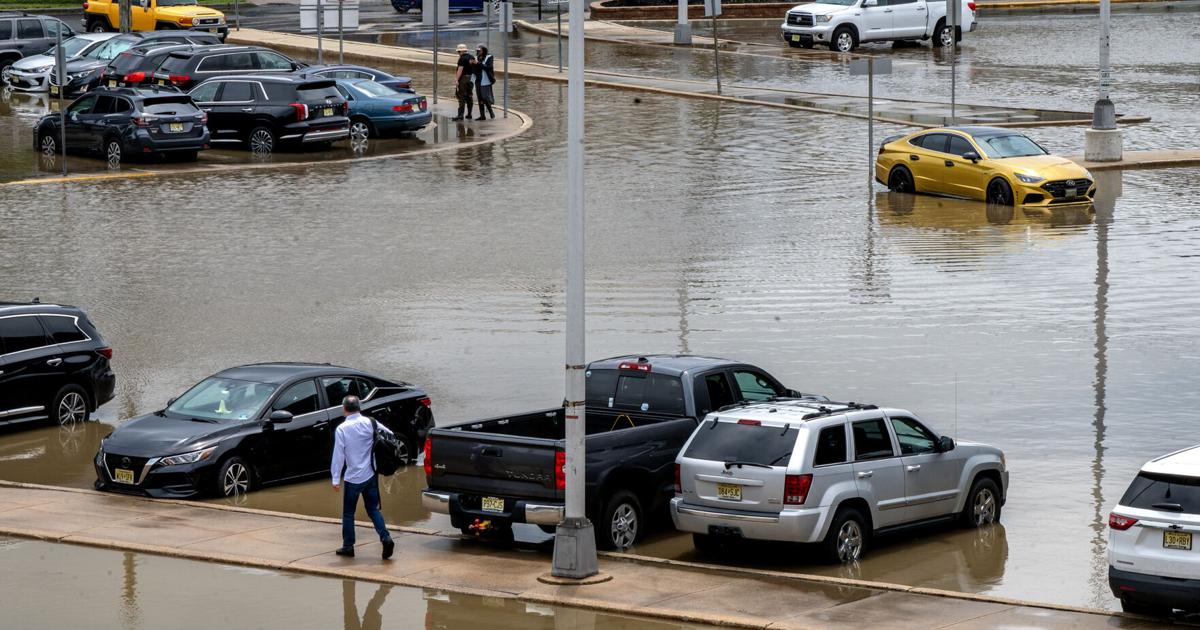Oscar Parra makes his way to his car in the flooded parking lot at the Ferry Avenue PATCO station in Camden earlier this month.