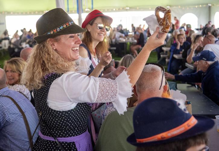 Melissa Drummond, left, and Kirsten Blake deliver pretzels inside the Oktoberfest beer and food tent