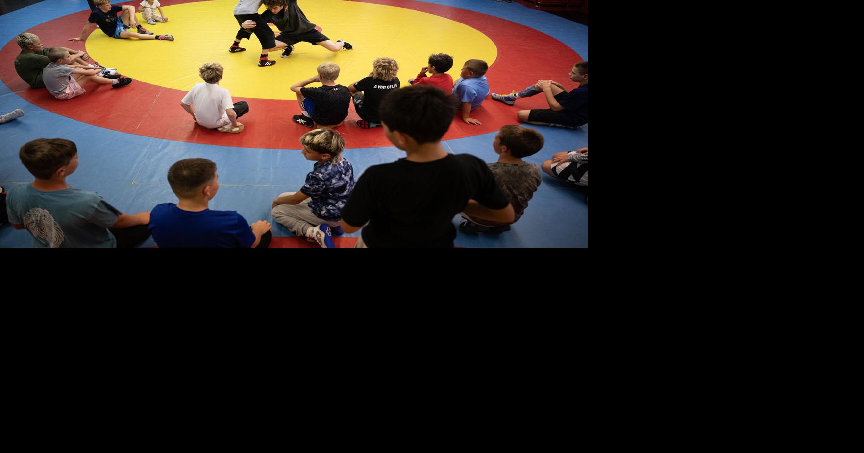 Wrestlers and parents look on as coach Vinny Zerban shows their next drill during a practice at Black Fox Wrestling Academy on Wednesday, Aug. 19, 2026, in Franktown, Colo..