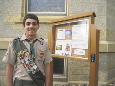Scout builds bulletin board for library to post events, news