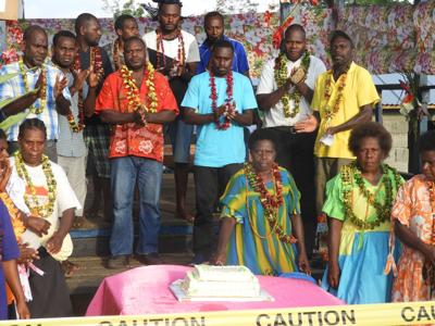 Max Albert (Blue shirt), Malekula Provincial Counselor (left)  while Max's mother seated in front of a Cake