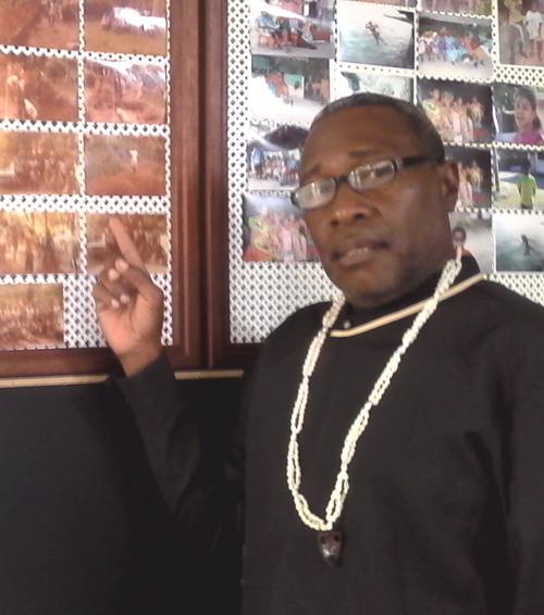Lulu Sopuso pointing to some of his photo collection